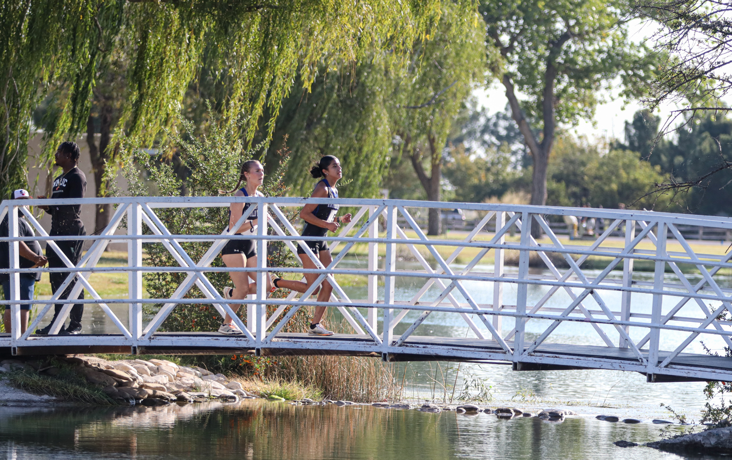 Mia Lujan and Mallory Moore crossing bridge at Harry McAdams Park at the Thunderbird Open